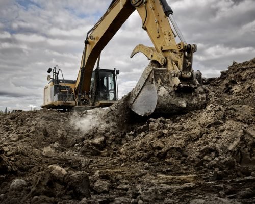 An excavator digging into the ground with its large bucket